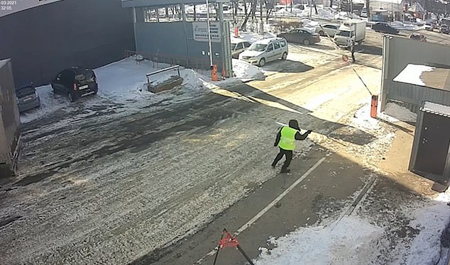 Imágenes de CCTV capturaron el momento cercano a la muerte en un depósito de camiones en Moscú, Rusia, el miércoles.  Aquí se ve a un colega corriendo hacia la choza para salvar a su compañero de trabajo.