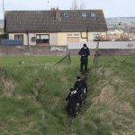 Los agentes de policía irlandeses descienden por una pendiente mientras registran un terreno baldío en Drogheda, donde se encontraron 'restos esqueléticos parciales' el jueves.