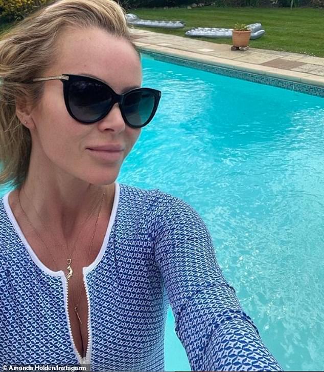 Belleza: Amanda Holden no decepcionó cuando publicó una autofoto chisporroteante en un traje de baño azul junto a una piscina el sábado.