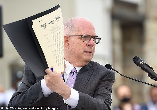 El gobernador de Maryland, Larry Hogan, sostiene un indulto que firmó durante un evento celebrado por el Maryland Lynching Memorial Project en la antigua cárcel del condado de Baltimore en Towson, Maryland.