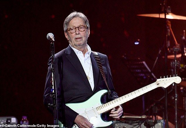 Eric Clapton ha criticado la 'propaganda' sobre la seguridad de las vacunas, alegando que sufrió efectos secundarios alarmantes después de sus golpes de Covid.  Aparece en la foto de arriba en un concierto en marzo de 2020.