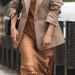 Elegante: Mollie King lucía elegante sin esfuerzo con un vestido marrón brillante mientras intentaba esquivar la lluvia de camino al trabajo el domingo.