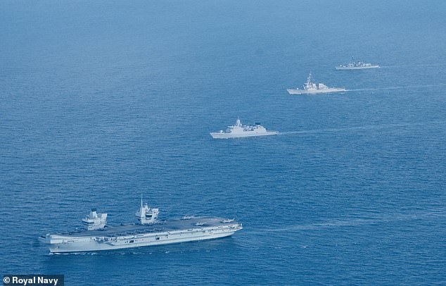 El HMS Queen Elizabeth (frente en la foto a principios de esta semana) ha llegado al Mar de China Meridional cuando Beijing amenaza con `` expulsar '' a los buques de guerra británicos si navegan cerca de las islas que reclama.