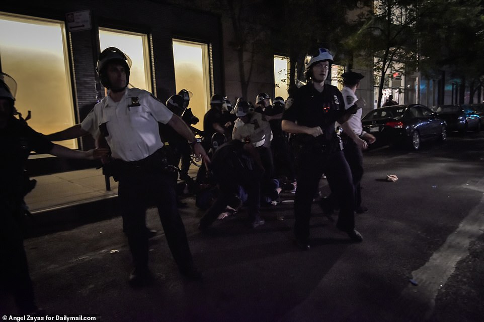 Se puede ver a los oficiales de policía de Nueva York con cascos deteniendo a un asistente a la fiesta en el suelo después de que se negaron a abandonar el área.
