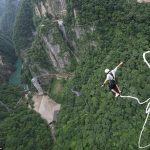 Los saltadores de puenting disfrutan de una vista aérea de la naturaleza salvaje de Wulingyuan, una popular atracción turística internacional, famosa por sus pilares y picos de arenisca de cuarcita que se extienden hacia las nubes, junto con profundos barrancos y gargantas.