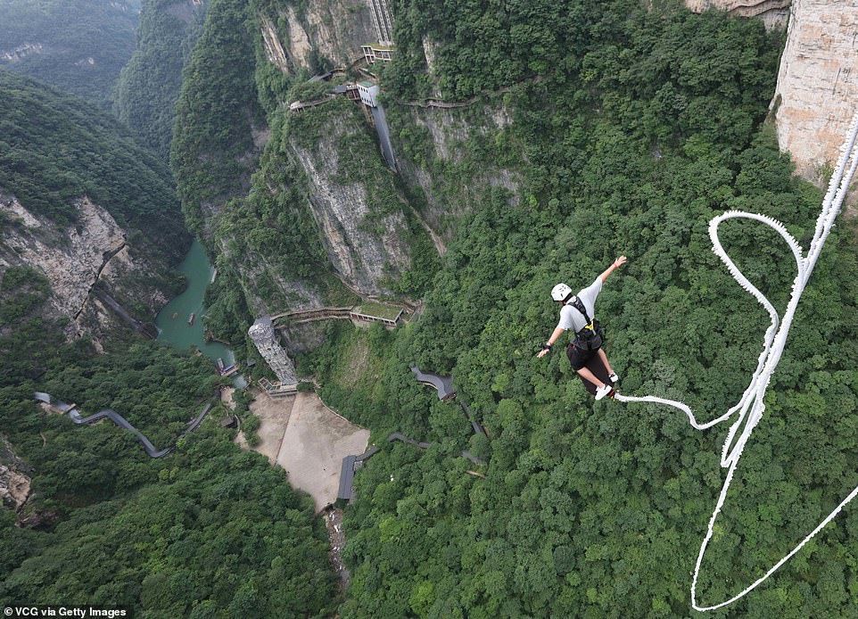 Los saltadores de puenting disfrutan de una vista aérea de la naturaleza salvaje de Wulingyuan, una popular atracción turística internacional, famosa por sus pilares y picos de arenisca de cuarcita que se extienden hacia las nubes, junto con profundos barrancos y gargantas.