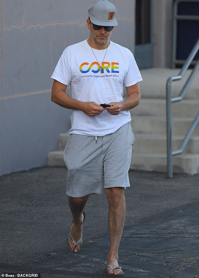 Bradley Cooper sale con una camiseta con estampado de arcoíris que anuncia la organización de ayuda ante desastres de Sean Penn