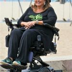 Abby Lee Miller de Dance Moms se recuesta en su silla de ruedas mientras una gimnasta da volteretas sobre ella