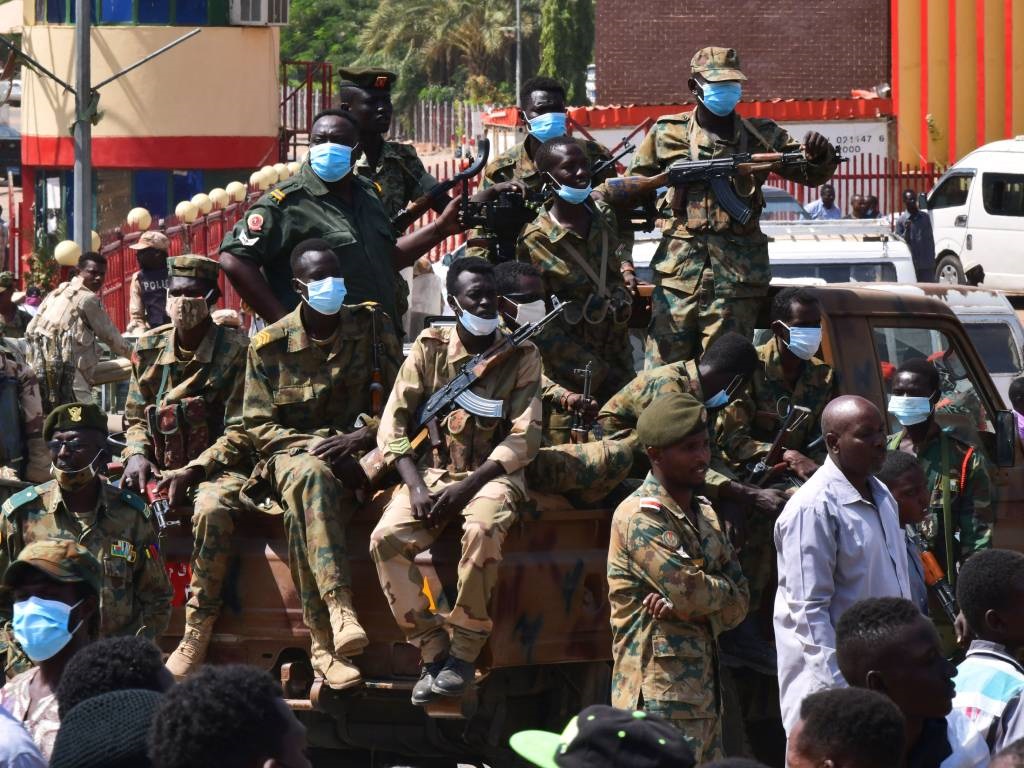 Sudanese security forces keep watch as they protec