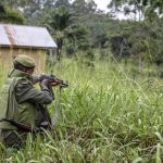 A soldier of the FARDC (Armed Forces of the Democratic Republic of the Congo) takes cover during exchanges of fire with members of the ADF (Allied Democratic Forces) in Opira, North Kivu, on January 25, 2018.