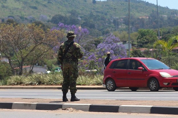 A soldier stands in the road in Manzini on October