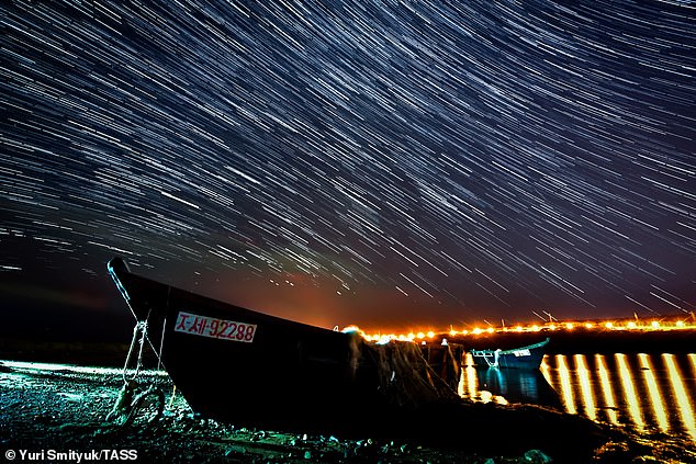 Las lluvias de meteoros se producen cuando la Tierra viaja a través de una nube de desechos cometarios.  En este caso, la lluvia de meteoros Draconid proviene de los escombros del cometa 21 P / Giacobini-Zinner.  En la imagen, el cielo nocturno sobre la isla Russky durante las Dracónidas.
