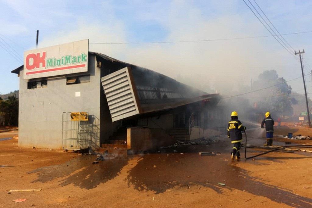 Firefighters extinguish a fire at a supermarket in Manzini, Eswatini on 30 June 2021 in the wake of protests.