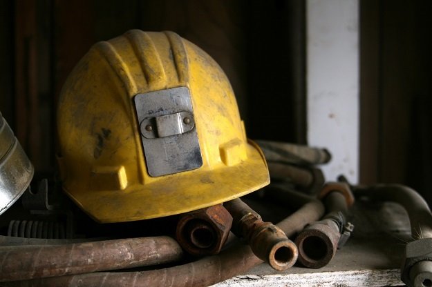 A yellow mining helmet on a pile of old hose.