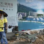 La paralización comercial del gigante inmobiliario chino Evergrande ha provocado una caída en las acciones mineras australianas (en la foto se muestra un trabajador junto a un anuncio de Evergrande en Hong Kong)