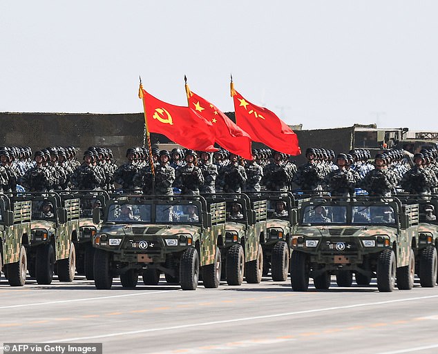 Los soldados chinos llevan las banderas del Partido Comunista del país durante un desfile militar.  Los países que no cuentan con las regulaciones cibernéticas adecuadas deben ser cautelosos a la hora de interactuar con China sobre problemas en línea, advirtió un nuevo informe.