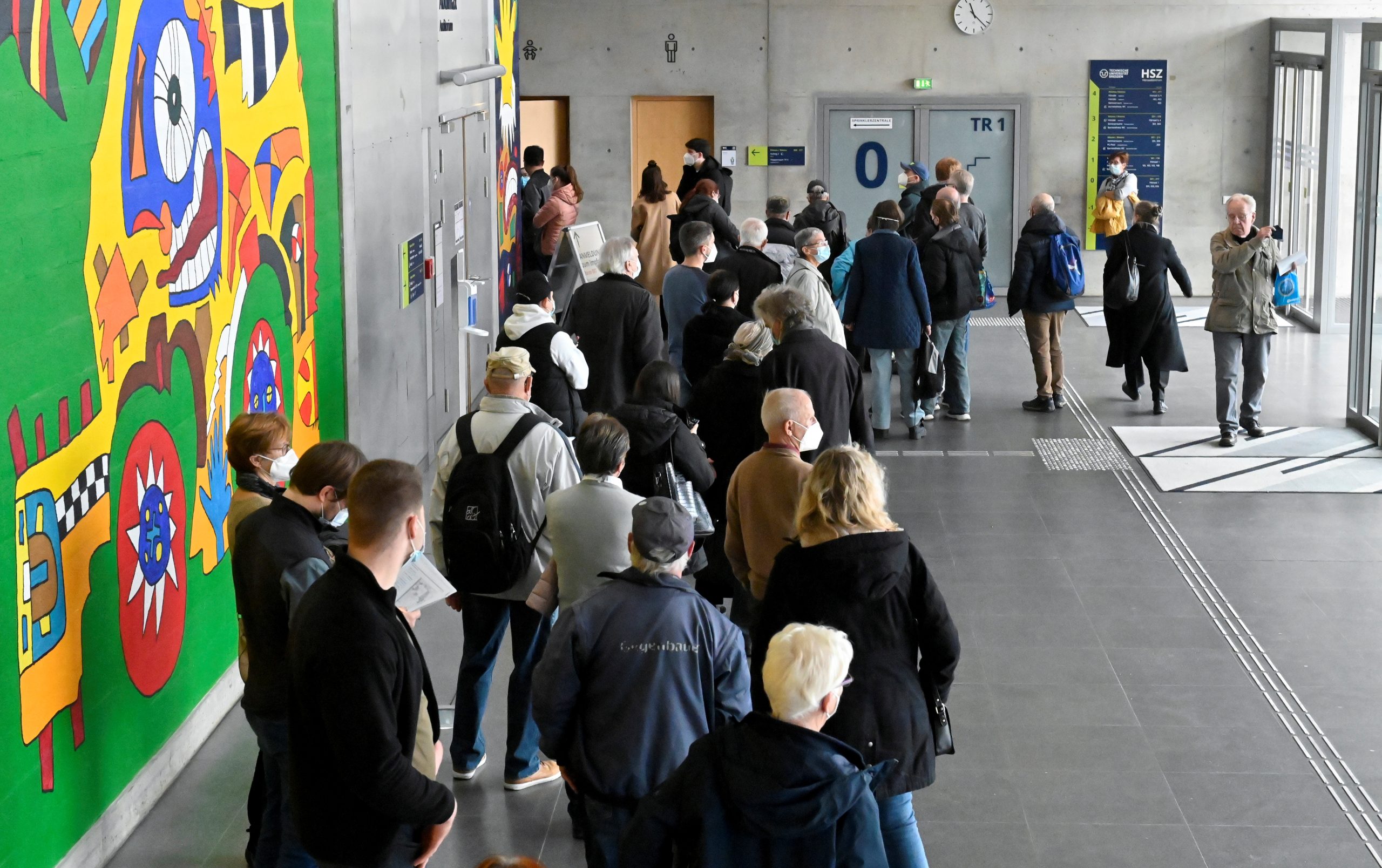 Personas hacen cola para vacunarse en un centro de vacunación temporal dentro del edificio del campus de la universidad Technische Universitaet en Dresden, Alemania, el 8 de noviembre de 2021. REUTERS / Matthias Rietschel