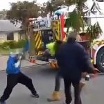 Un hombre (con chaqueta de flúor) se peleó con otro hombre en la calle mientras los bomberos intentaban salvar su casa en llamas.
