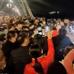 Se puede ver a cientos de personas reunidas en el puente, en Kaifeng, provincia de Henan, en el norte de China, un lugar popular para que las personas influyentes transmitan en vivo.