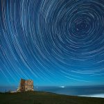 Una imagen superpuesta de 128 fotografías muestra estelas de estrellas circumpolares sobre la torre de San Telmo en Ubiarco, Cantabria, España, a principios del 14 de diciembre de 2021, durante la lluvia de meteoritos de las Geménidas.