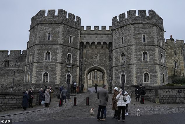 Párese turístico frente a la puerta de Enrique VII y tome fotografías en el castillo de Windsor en Windsor, Inglaterra, el día de Navidad