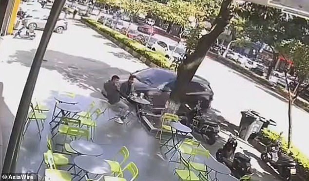 El automóvil en la ciudad de Zhongshan, China, giró a la derecha y estuvo a centímetros de golpear a dos hombres sentados afuera de un bar.