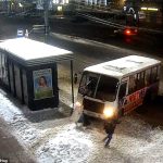 La mujer, que no parece darse cuenta de que el autobús está a punto de golpearla, cae en la nieve en Yaroslavl, Rusia.