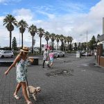 En la imagen: una mujer camina por una calle casi vacía en Bondi Beach.  NSW registró 20,148 y 30 muertes el sábado