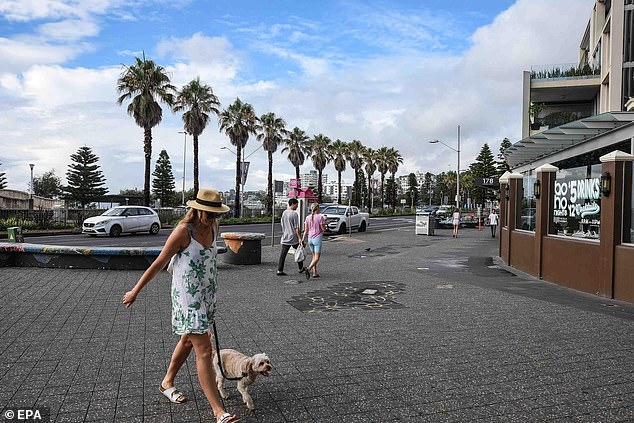 En la imagen: una mujer camina por una calle casi vacía en Bondi Beach.  NSW registró 20,148 y 30 muertes el sábado