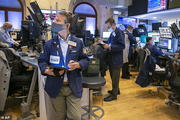 Los comerciantes trabajan en el piso de la Bolsa de Valores de Nueva York el martes.  Las acciones han estado girando en un comercio salvaje antes de la decisión de política de la Fed prevista para el miércoles.