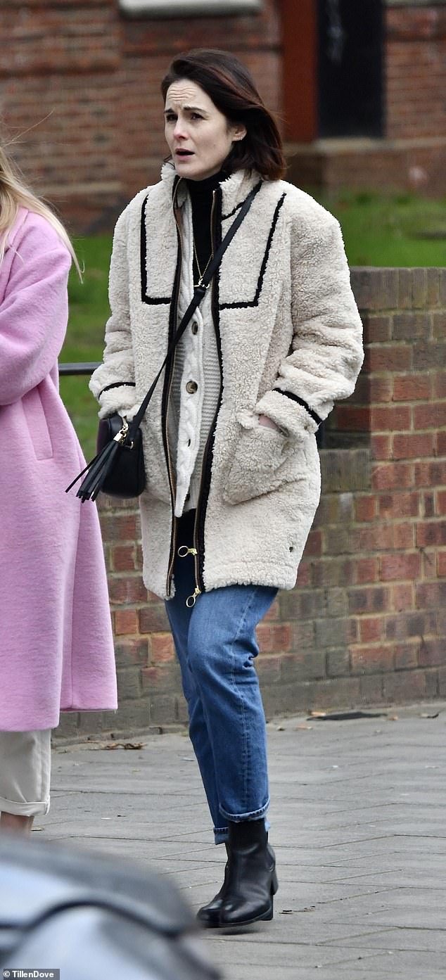 Abrigada: Michelle Dockery vista usando un anillo de diamantes en su dedo anular después de anunciar su compromiso con Jasper Waller Bridge