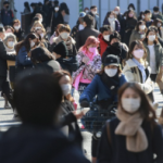 Personas con mascarillas para protegerse contra la propagación del coronavirus caminan por una calle en Tokio, el 2 de febrero de 2022. (AP Photo/Koji Sasahara)