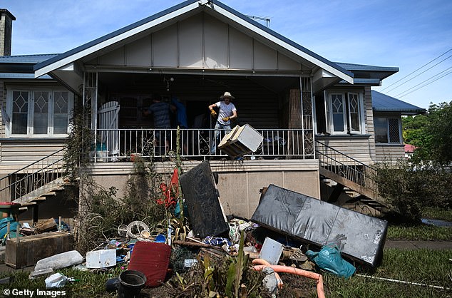 El principal funcionario de recuperación del país instó a los australianos cuyas casas resultaron dañadas por las inundaciones a que no reconstruyan y, en cambio, se trasladen a áreas menos propensas a inundaciones.  En la foto, un hombre arroja bienes dañados desde una casa afectada en Lismore.