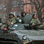 Los miembros del servicio de las tropas prorrusas se ven encima de un vehículo blindado durante el conflicto Ucrania-Rusia en la ciudad portuaria sureña de Mariupol.