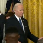 Se ve a Joe Biden deambulando por el East Room buscando a alguien con quien hablar
