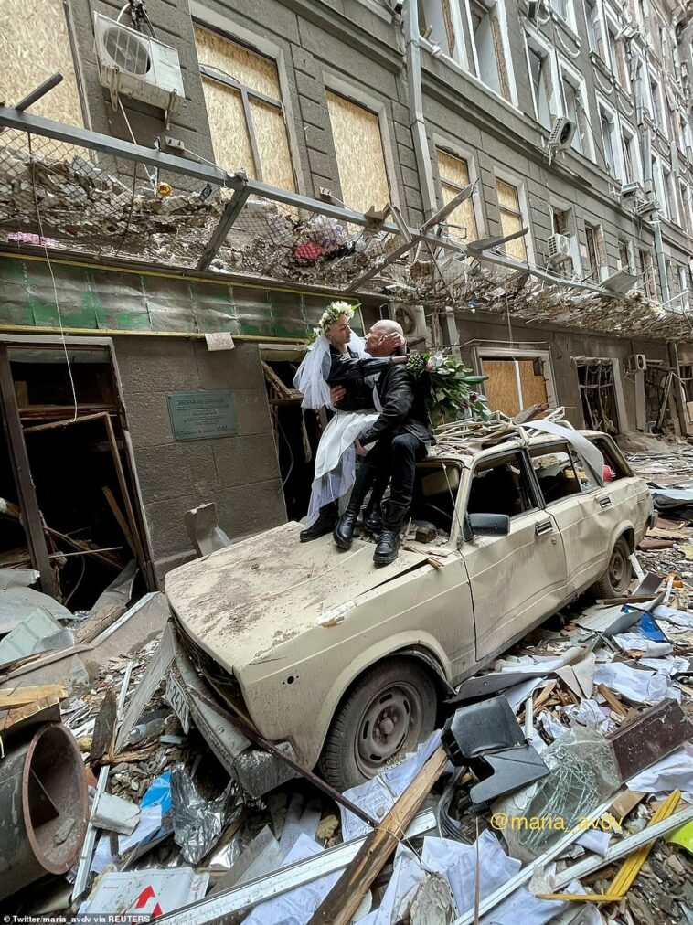 Los recién casados ​​Nastya Gracheva y Anton Sokolov fueron fotografiados poco después de casarse el domingo entre los escombros de un complejo comercial y de oficinas en la segunda ciudad más grande de Ucrania.