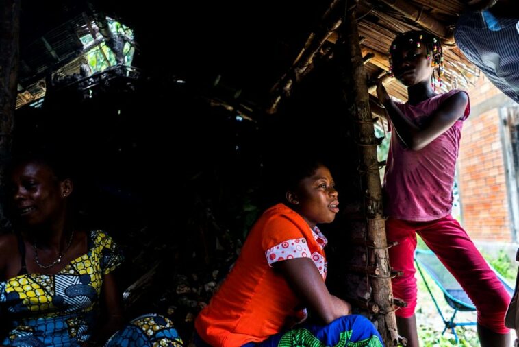 At left, Manfuette villagers Laur with her two daughters, Janelle and unidentified younger daughter, prepare the daily meal for the CDC scientists and Congolese scientists after a day of MonkeyPox research in Manfuette, Republic of Congo Tuesday August 29, 2017. In a remote northern village within Central Africa, a team from the Center of Disease Control research the MonkeyPox virus on the ground. (Photo by Melina Mara/The Washington Post via Getty Images)