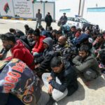 Members of Libyan security forces accompany migran