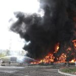 Los bomberos del Ministerio de Situaciones de Emergencia de la República Popular de Donetsk trabajan en el lugar del incendio en el depósito de petróleo después de que los misiles golpearan la instalación en un área controlada por las fuerzas separatistas respaldadas por Rusia en Makiivka.