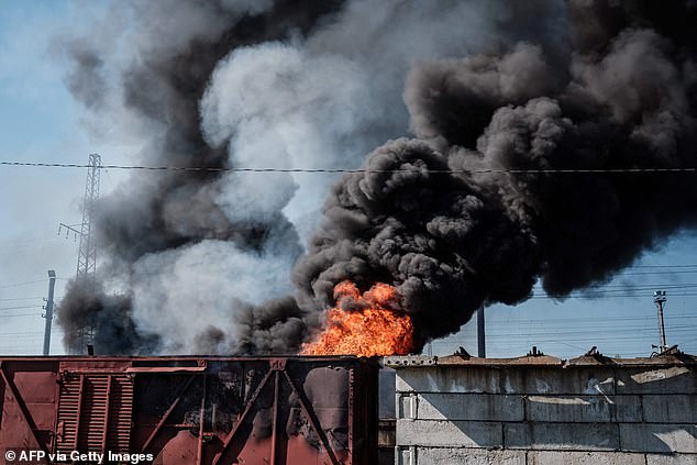 Un automóvil y durmientes apilados están ardiendo después de un bombardeo cerca de la estación de Lyman en Lyman, este de Ucrania, a principios de esta semana.  Cuatro civiles murieron hoy en un nuevo bombardeo de la ciudad en medio del asalto de Rusia a lo largo del frente oriental en la región de Donbass.