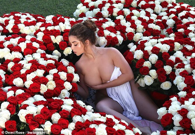 Flower power: Demi Rose hizo alarde de sus increíbles curvas en una sesión de fotos de flores picantes el martes que la vio rodeada de ramos románticos, aparentemente sin nada más que una sábana.