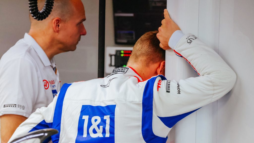 Mick Schumacher speaking with a Haas engineer, looking around the wall. Australia April 2022