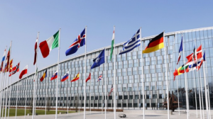 La foto tomada el 24 de marzo de 2022 muestra las banderas de la Organización del Tratado del Atlántico Norte (C) y sus países miembros en la sede de la OTAN en Bruselas.  (Kiodo)