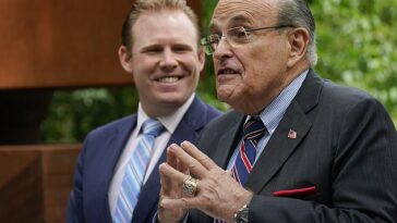 Rudy Giuliani fue atacado por un trabajador de un supermercado en Staten Island el domingo mientras hacía campaña por su hijo, Andrew, a la izquierda, cuando lo abofetearon (foto de archivo)