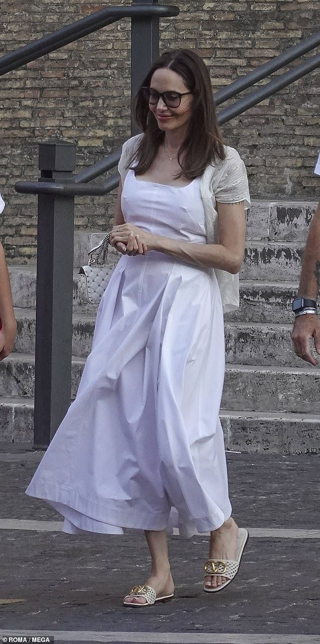 Impresionante: Angelina Jolie lució el epítome de la elegancia con un maxi vestido blanco el miércoles mientras disfrutaba de un día en el Museo del Vaticano en Roma.