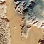 El enorme cañón del Planeta Rojo ha sido revelado en nuevas imágenes publicadas por la Agencia Espacial Europea.  La nueva imagen muestra dos trincheras, o chasma, que forman una parte de la parte occidental de Valles Marineris.  A la izquierda está el lus Chasma de 521 millas de largo y a la derecha está el Tithonium Chasma de 500 millas de largo.