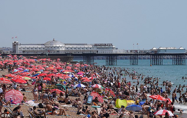 El calor abrasador en Gran Bretaña la semana pasada hizo que las temperaturas superaran los 104 °F (40 °C) por primera vez en el país.  Ahora, los investigadores dicen que el cambio climático causado por el hombre hizo que la ola de calor récord sea 'al menos 10 veces más probable' En la foto, la playa de Brighton el 19 de julio de 2022
