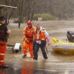 Un hombre es rescatado de su automóvil por trabajadores del Servicio de Emergencia del Estado en Windsor el 4 de julio de 2022 en Sydney, Australia.