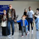 Josh Homme, líder de Queens of the Stone Age, se ve en el aeropuerto de Los Ángeles sosteniendo la mano de su hijo Wolf, de seis años.  Un niño que se cree que es Orrin, de diez años, camina detrás, al igual que una niña que se cree que es Camille, de 15 años, con jeans azules y un sombrero de pescador.