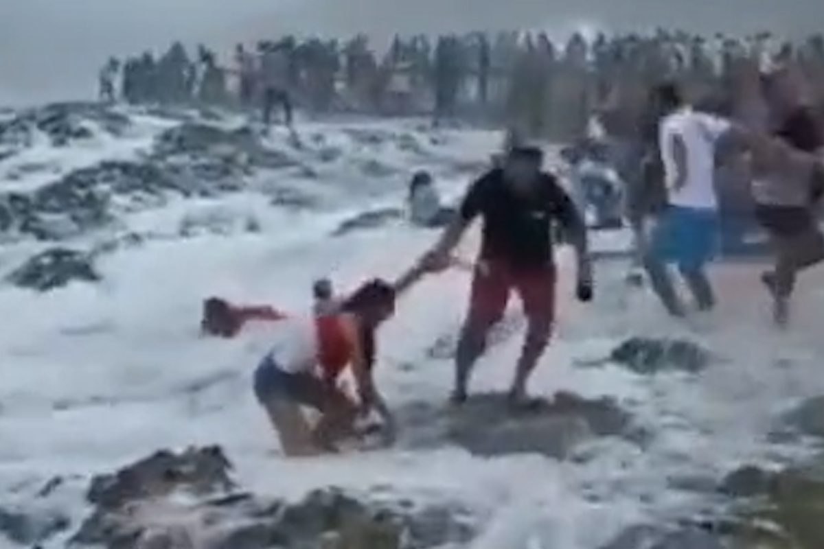 Familia india arrastrada por las olas en la playa de Omán
